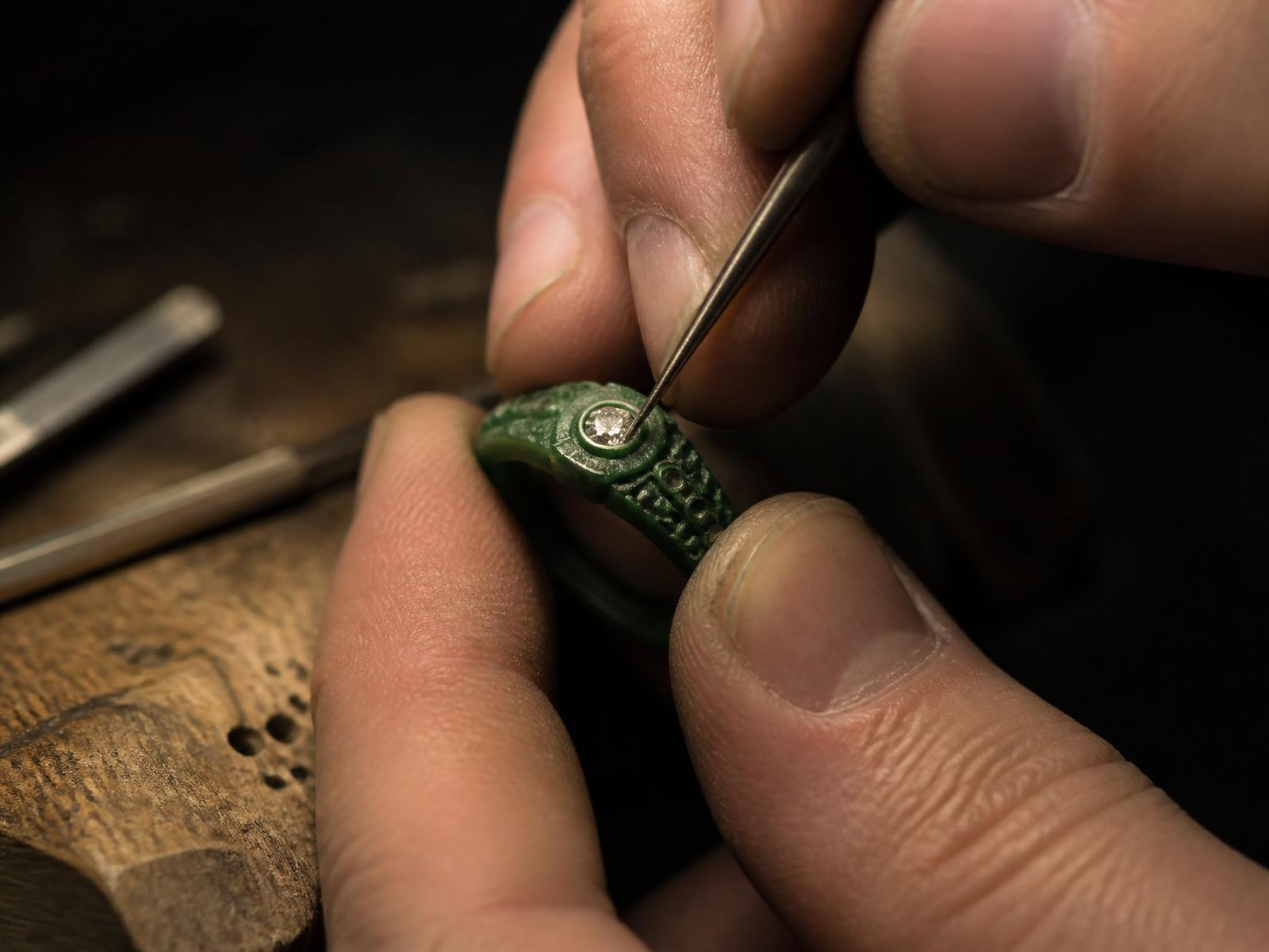Jeweler setting a diamond into a wax ring model.